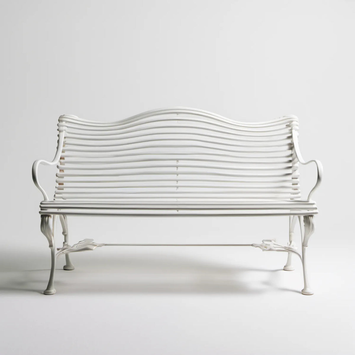 Biała dwuosobowa ławka ogrodowa z odlewanego aluminium, faliste oparcie, 130 x 60 x 90 cm